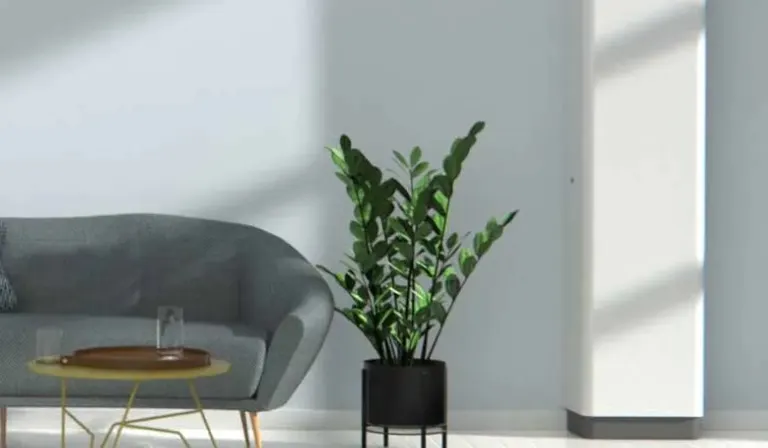 Produktbillede af en hvid mobil sprinkler ved siden af en sofa